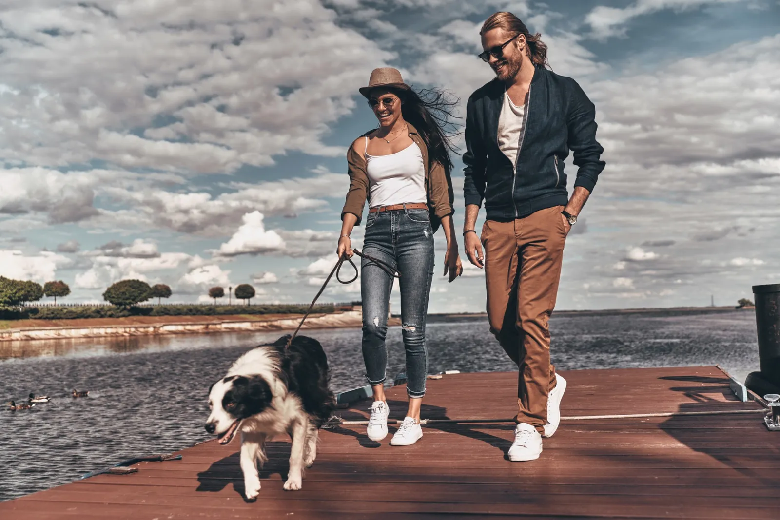 Couple walking their dog by the water